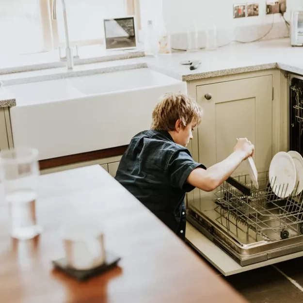 Teenage Boy Loading Dishwasher