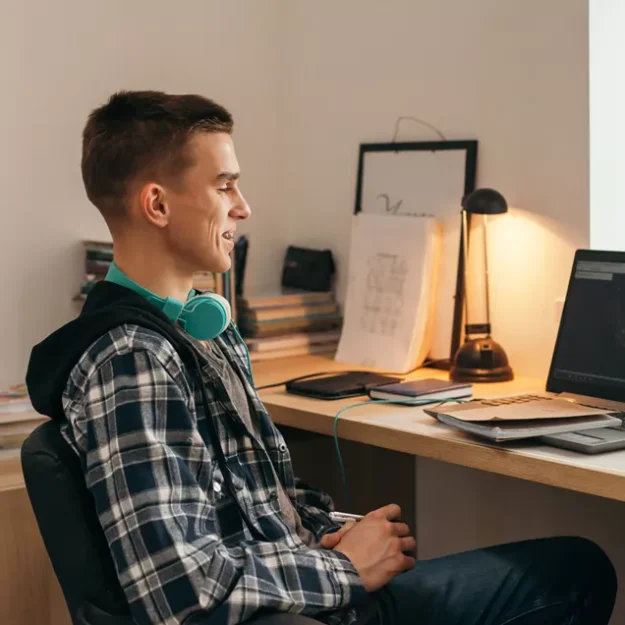 Young Male Using Laptop At Desk