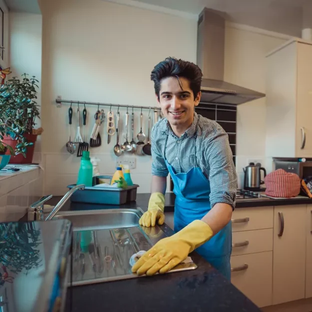 Young Man Cleaning The Kitchen