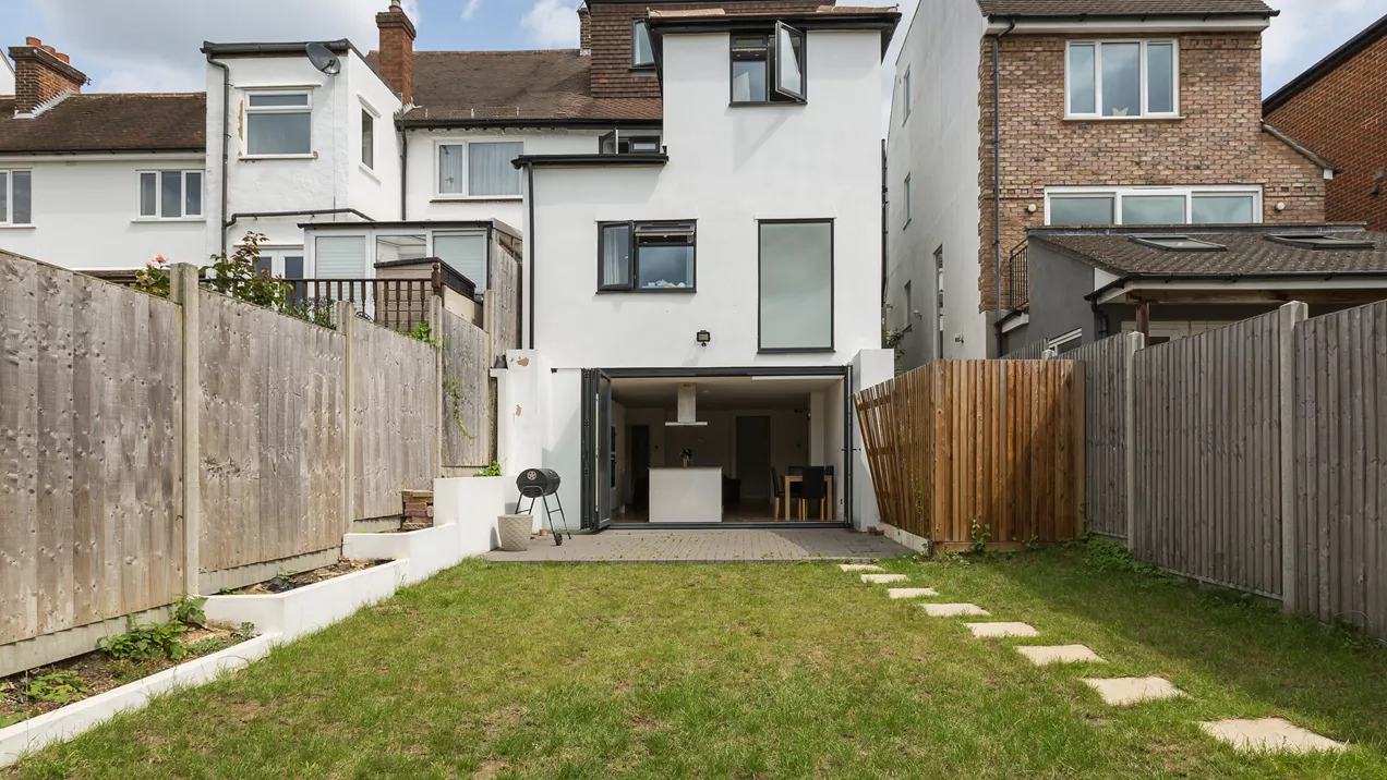 View from a shared house garden looking back at kitchen and bi-fold doors